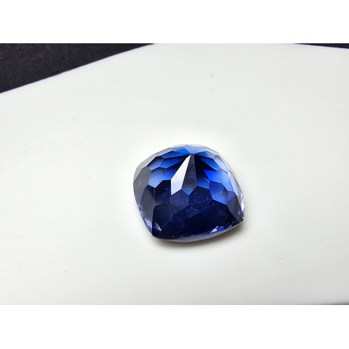 251 - A cased large lab created cushion cut faceted blue sapphire gemstone complete with its presentation ... 