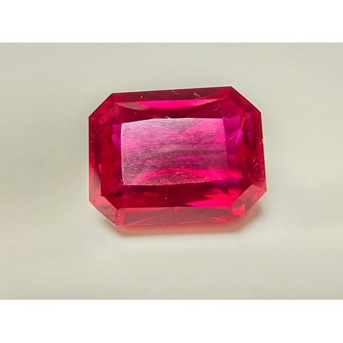 253 - A cased large lab created rectangular cut faceted red ruby  gemstone complete with its presentation ... 