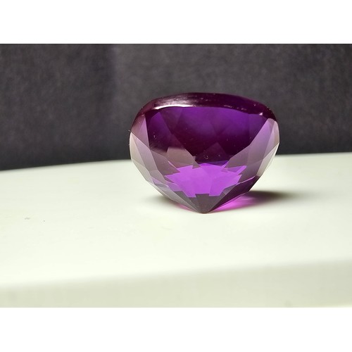 254 - A cased large lab created cushion cut faceted purple sapphire gemstone complete with its presentatio... 