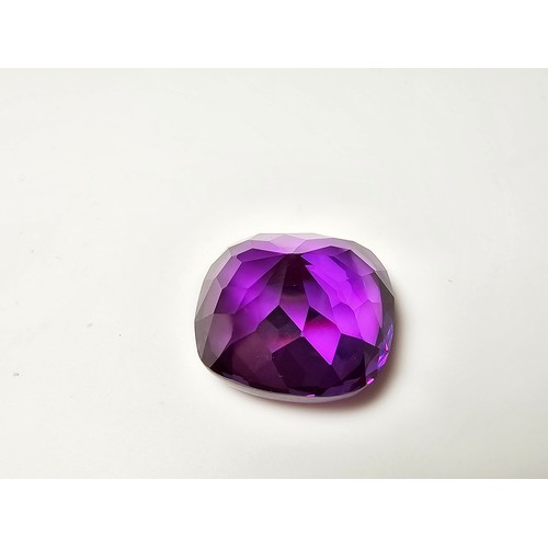 254 - A cased large lab created cushion cut faceted purple sapphire gemstone complete with its presentatio... 