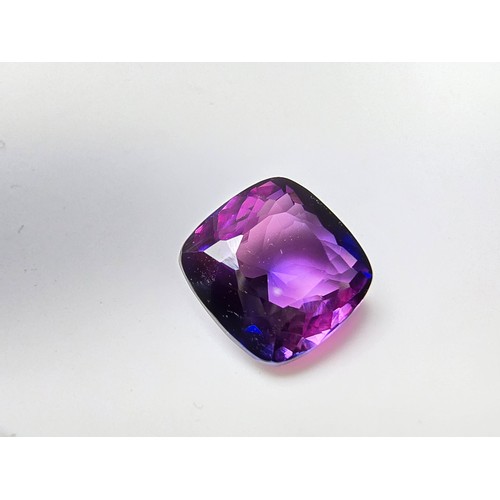 255 - A cased large lab created cushion cut faceted purple sapphire gemstone has a lovely blue to purple h... 