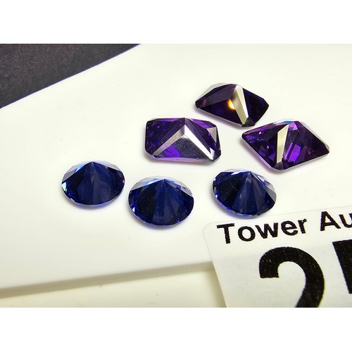 256 - A collection of 6x lab created faceted iolite gemstones, all of various shapes and sizes. Length  of... 