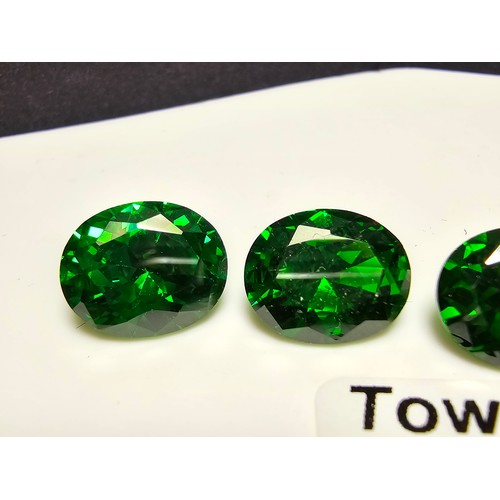 257 - A collection of 6x lab created faceted emerald gemstones, all oval cut. Length of 10mm, width 7mm, h... 