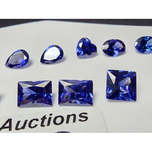 259 - A collection of 13x lab created faceted iolite gemstones, all of various shapes and sizes includes  ... 