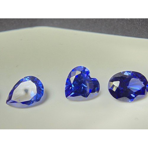 259 - A collection of 13x lab created faceted iolite gemstones, all of various shapes and sizes includes  ... 