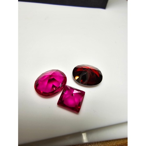 260 - A collection of 9x lab created faceted ruby gemstones along with a faceted almandine garnet gemstone... 