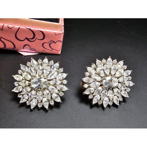 176 - A pair of art deco style sterling silver clip on cluster earrings inset with a large quantity of CZ ... 