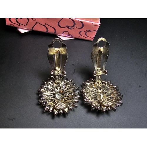 176 - A pair of art deco style sterling silver clip on cluster earrings inset with a large quantity of CZ ... 