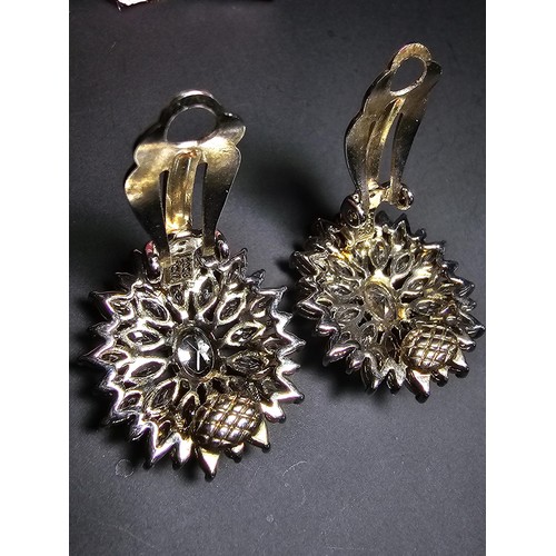 176 - A pair of art deco style sterling silver clip on cluster earrings inset with a large quantity of CZ ... 