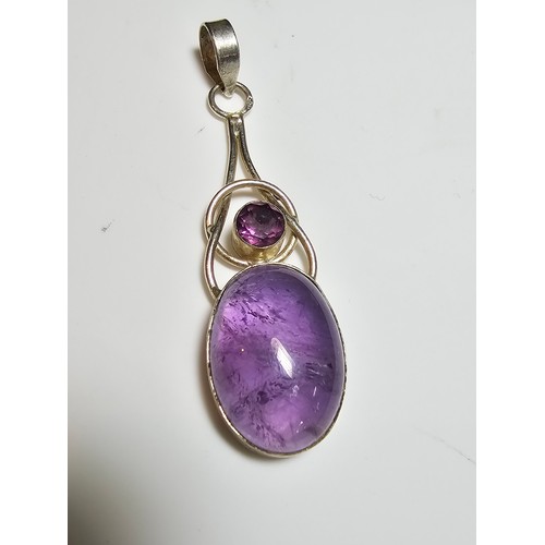 188 - A pretty 925 silver long drop pendant inset with a large natural amethyst oval stone and a round fac... 