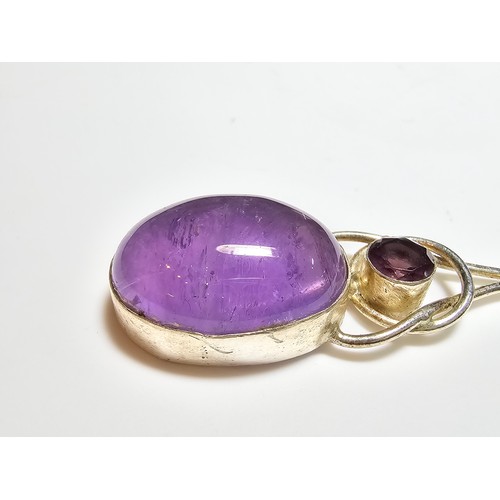 188 - A pretty 925 silver long drop pendant inset with a large natural amethyst oval stone and a round fac... 