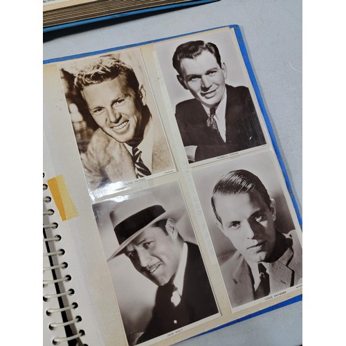 125 - 2x blue albums containing a large quantity of Hollywood stars of the past inc Nat King Cole, Gary Co... 