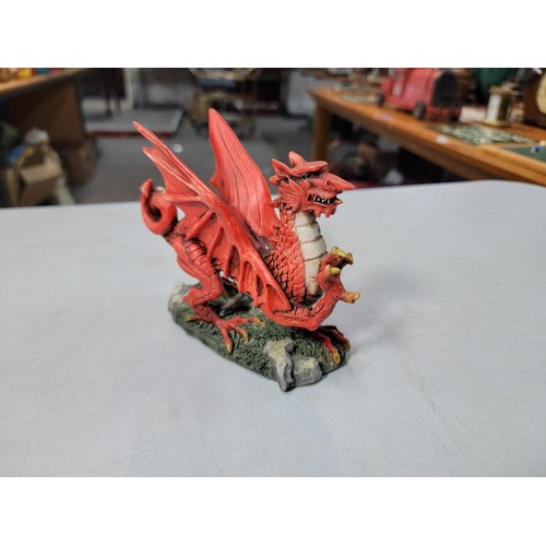 133 - Resin Welsh dragon formed figure along with a battery operated resin carousel with fully revolving t... 