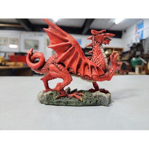 133 - Resin Welsh dragon formed figure along with a battery operated resin carousel with fully revolving t... 