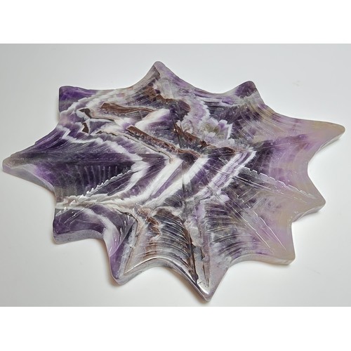 220 - An unusual crystal ornament of a large carved natural amethyst cobweb which sits on a black metal st... 