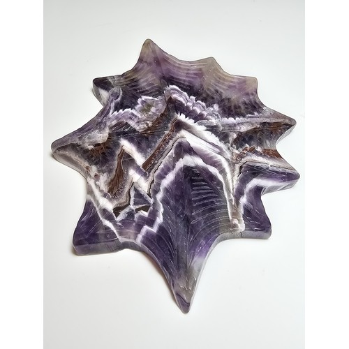 220 - An unusual crystal ornament of a large carved natural amethyst cobweb which sits on a black metal st... 