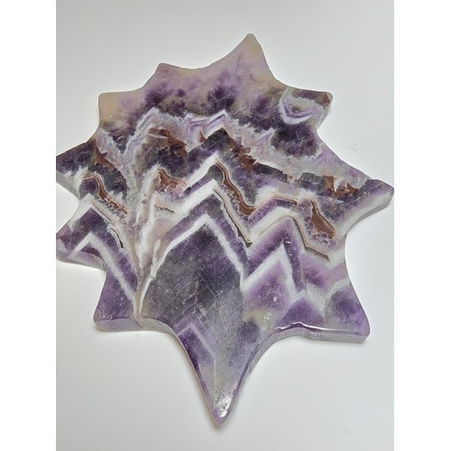 220 - An unusual crystal ornament of a large carved natural amethyst cobweb which sits on a black metal st... 