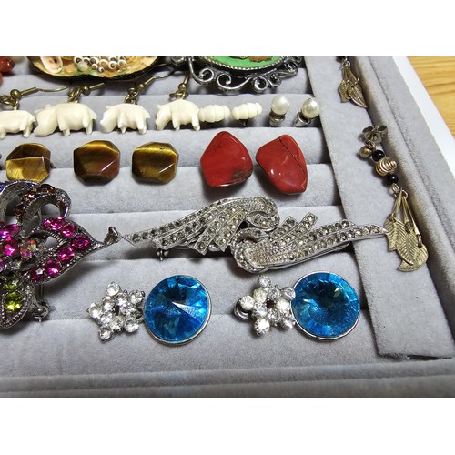 226 - A ring display box containing a large quantity of costume jewellery which includes ornate brooches, ... 