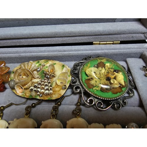 226 - A ring display box containing a large quantity of costume jewellery which includes ornate brooches, ... 