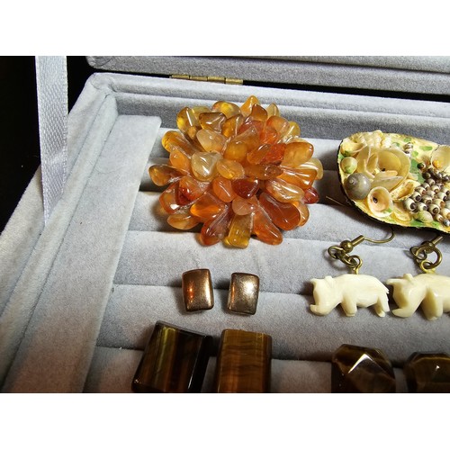 226 - A ring display box containing a large quantity of costume jewellery which includes ornate brooches, ... 