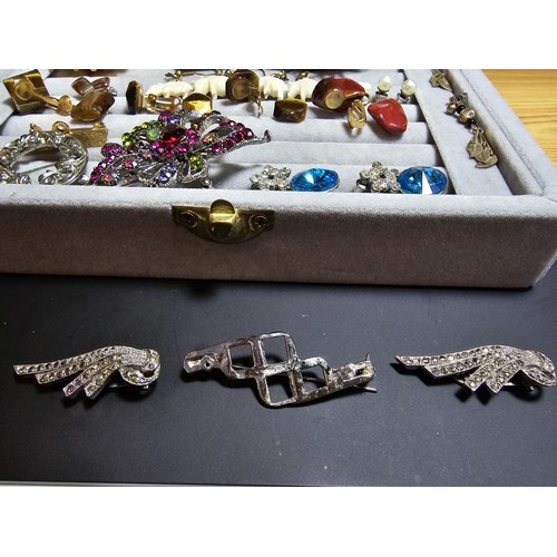 226 - A ring display box containing a large quantity of costume jewellery which includes ornate brooches, ... 