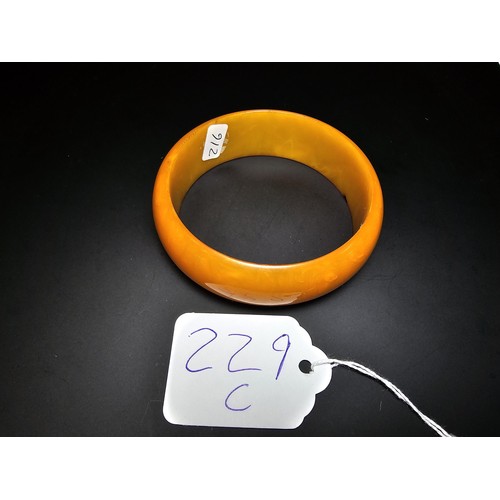 229C - A good quality genuine solid butterscotch amber carved bangle presenting an excellent natural swirle... 