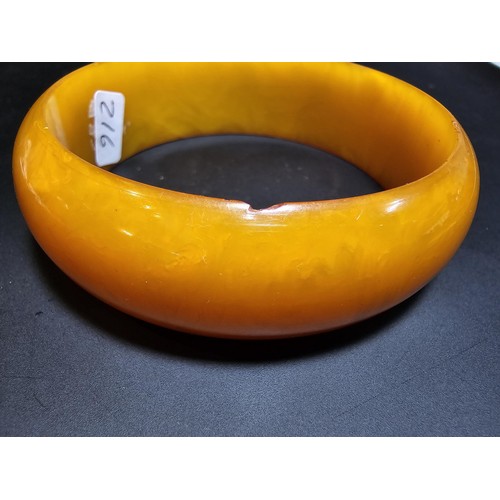 229C - A good quality genuine solid butterscotch amber carved bangle presenting an excellent natural swirle... 