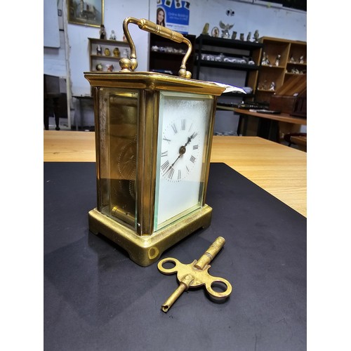 281 - A good quality antique brass cased carriage clock featuring a porcelain dial and bevelled glass view... 