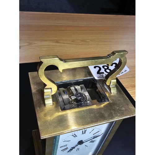 283 - A good quality antique brass cased carriage clock featuring thick gauge brass panels having a porcel... 