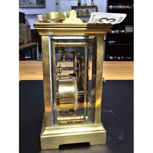 283 - A good quality antique brass cased carriage clock featuring thick gauge brass panels having a porcel... 