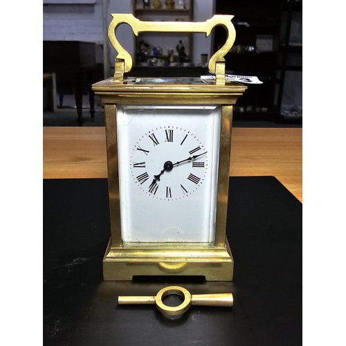 283 - A good quality antique brass cased carriage clock featuring thick gauge brass panels having a porcel... 