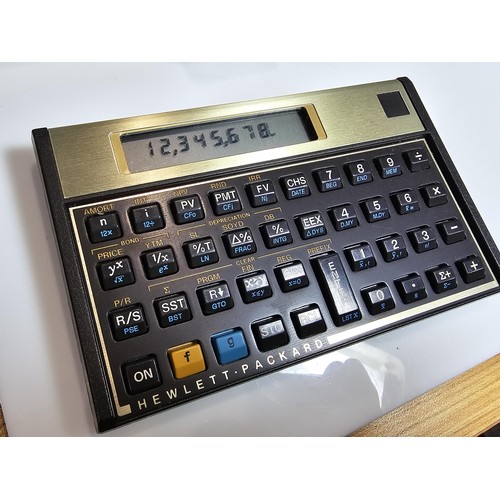 296 - A Hewlett Packard HP-12C business financial calculator in gold and black, complete with its original... 