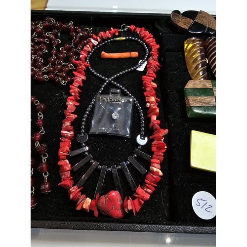 297 - A black display board full of various good costume jewellery which includes a large and impressive g... 