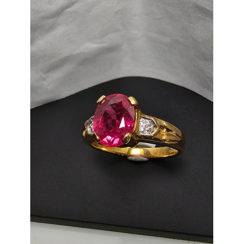 221 - Stunning hallmarked 9ct yellow gold ring inset with a large oval natural ruby faceted gemstone with ... 