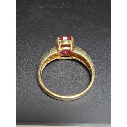 221 - Stunning hallmarked 9ct yellow gold ring inset with a large oval natural ruby faceted gemstone with ... 