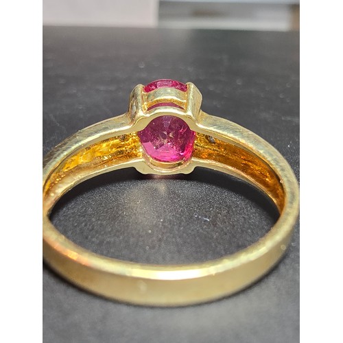 221 - Stunning hallmarked 9ct yellow gold ring inset with a large oval natural ruby faceted gemstone with ... 