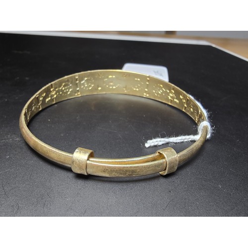 213 - A good quality gold plate on solid 925 sterling silver adjustable bangle, having an engraved star de... 