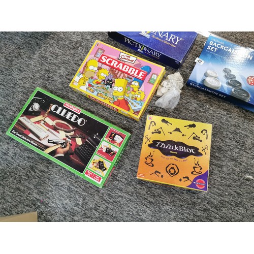 42 - A large quantity of board games to include the Simpsons Scrabble, a vintage Cluedo, table tennis, tr... 