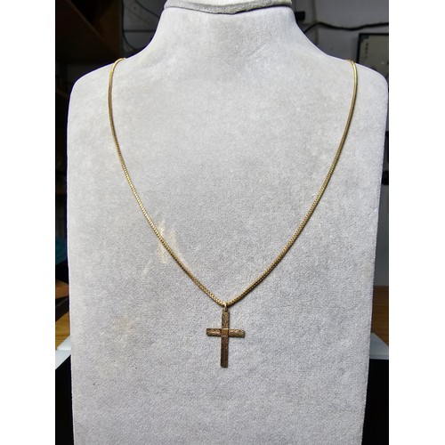 227 - A 9ct yellow gold cross pendant set on a very long gold plated 27