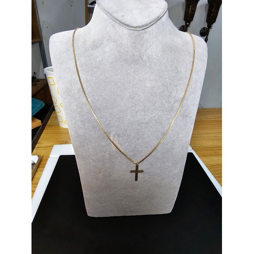 227 - A 9ct yellow gold cross pendant set on a very long gold plated 27