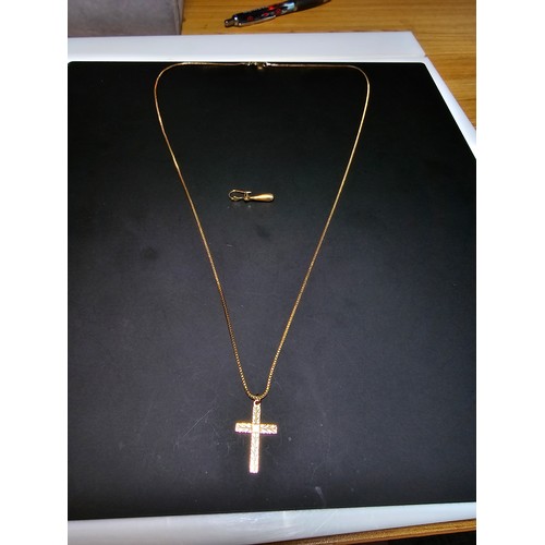 227 - A 9ct yellow gold cross pendant set on a very long gold plated 27