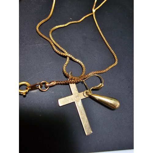 227 - A 9ct yellow gold cross pendant set on a very long gold plated 27