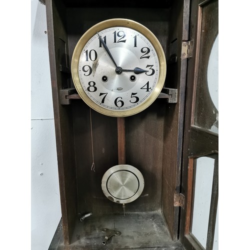 88 - Vintage oak wall clock complete with pendulum and key. Measures 68cm x 33.5cm x 18cm.