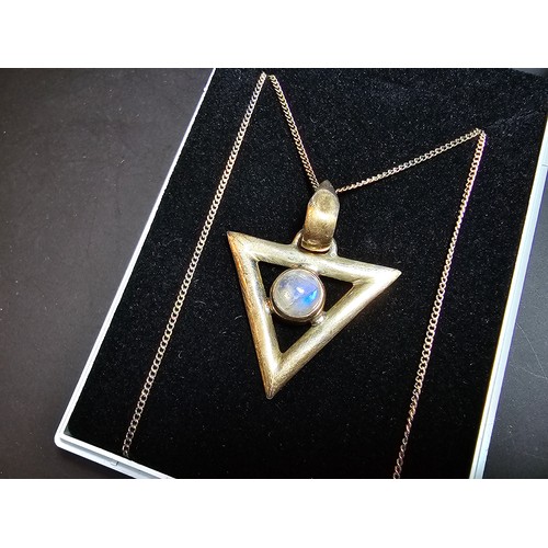 141 - An unusual 925 silver triangular pendant inset with a rainbow moonstone featuring good flashing blue... 