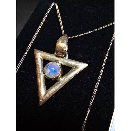 141 - An unusual 925 silver triangular pendant inset with a rainbow moonstone featuring good flashing blue... 