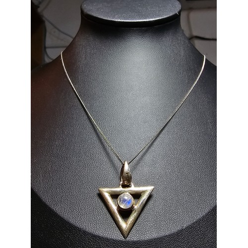 141 - An unusual 925 silver triangular pendant inset with a rainbow moonstone featuring good flashing blue... 