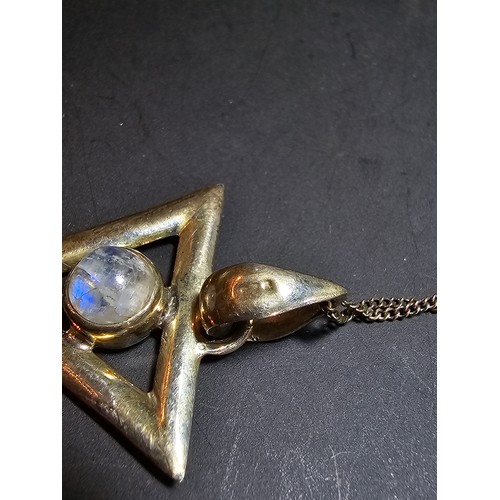 141 - An unusual 925 silver triangular pendant inset with a rainbow moonstone featuring good flashing blue... 