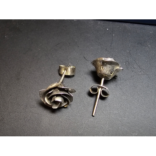 142 - A pretty pair of 925 silver rose and stem formed earrings complete with their butterfly backs. In ex... 