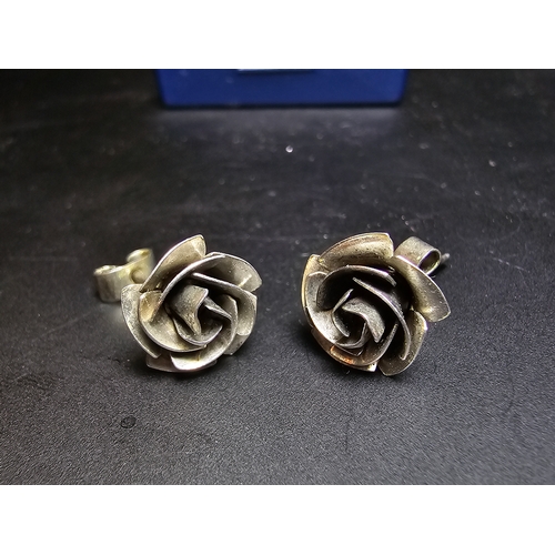 142 - A pretty pair of 925 silver rose and stem formed earrings complete with their butterfly backs. In ex... 