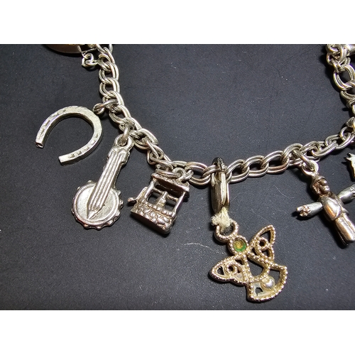 144 - A good 925 silver charm bracelet with 13x different silver charms and 925 silver padlock clasp with ... 